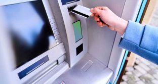Person insert plastic credit card into street atm bank to withdrawing money