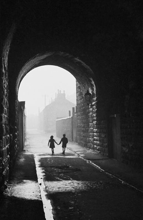 Bert hardy, A boy and a girl hold hands under an archway in the gorbals, a slum district of glas.jpg